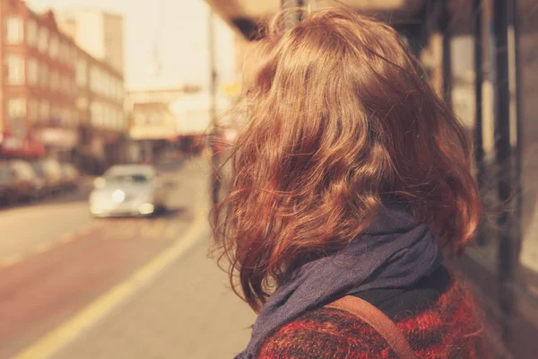 Young woman at bust stop — Stock Photo, Image