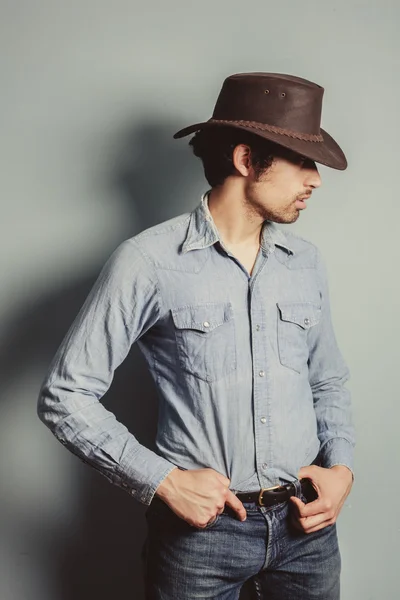 Cowboy debout près d'un mur bleu — Photo