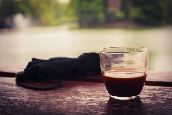 Coffee and umbrella by the lake — Stock Photo, Image