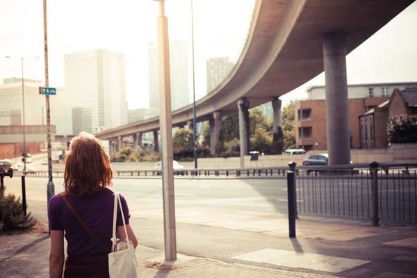 Young woman walking by the roadside — Stock Photo, Image