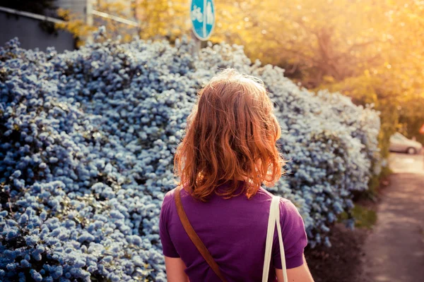 Jeune femme marchant dans la rue par une journée ensoleillée — Photo