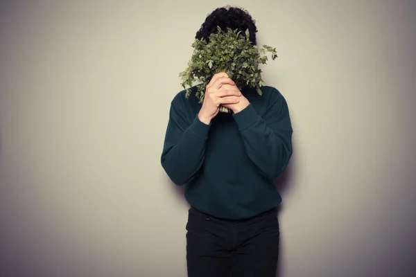 Young man hiding behind parsley — Stock Photo, Image