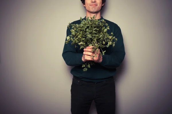 Happy young man with a big bunch of parsley — Stock Photo, Image