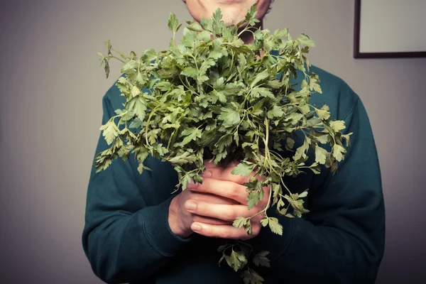 Gelukkig jonge man met een grote bos van peterselie — Stockfoto