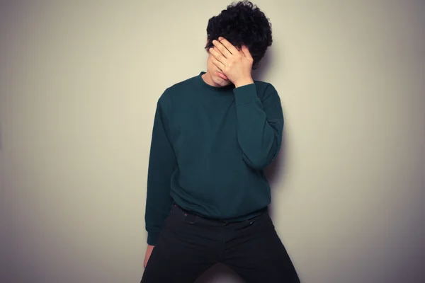 Jonge man met zijn palmen op zijn gezicht — Stockfoto