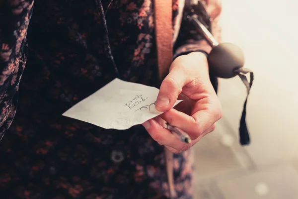 Mujer joven sosteniendo una nota — Foto de Stock