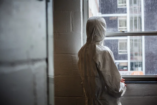 Wetenschapper in ketel suit door venster — Stockfoto