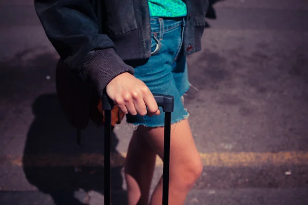 Jovem mulher de pé na rua com uma mala — Fotografia de Stock