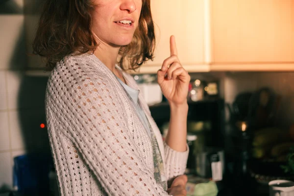 Mujer joven de pie en su cocina y pensando —  Fotos de Stock