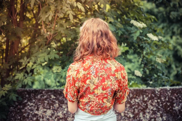 Mladá žena stojící mimo obklopena kvetoucí stromy — Stock fotografie