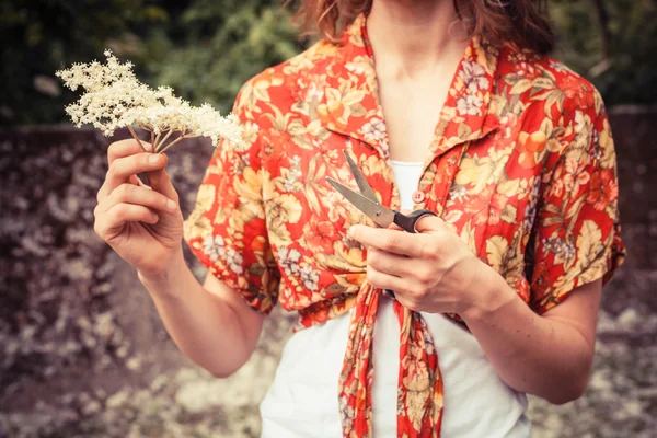 Jovem mulher de pé do lado de fora cercada por árvores florescentes — Fotografia de Stock