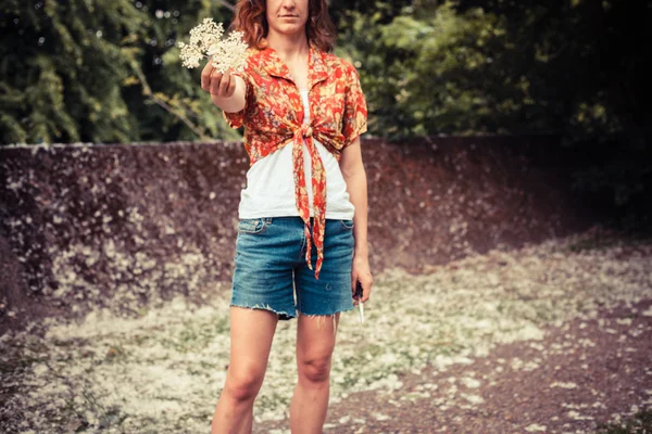 Junge Frau hält einen Strauß Holunderblüten in der Hand — Stockfoto