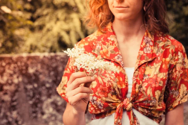 Jovem segurando um monte de flores de ancião — Fotografia de Stock