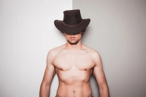 Jovem sem camisa cowboy contra verde e branco fundo — Fotografia de Stock