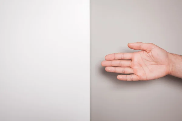 Aanbieden van handdruk tegen split gekleurde achtergrond — Stockfoto