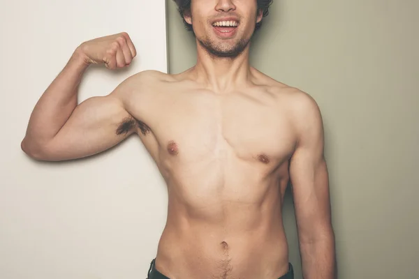 Young athletic man flexing his muscles — Stock Photo, Image