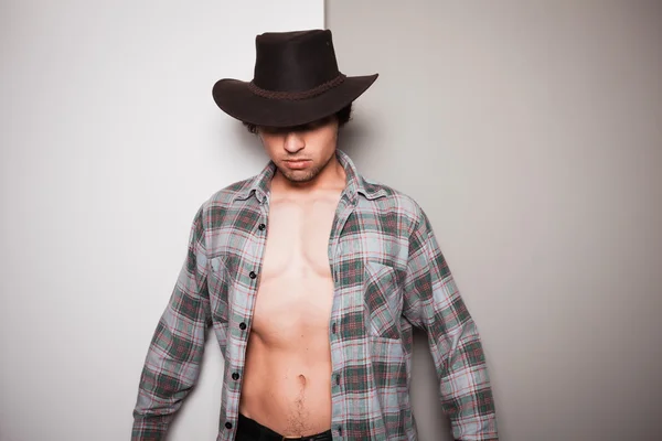 Ung cowboy stående mot dubbla färgad bakgrund — Stockfoto