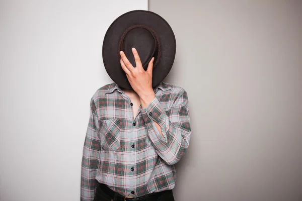 Young cowboy standing against dual colored background — Stock Photo, Image