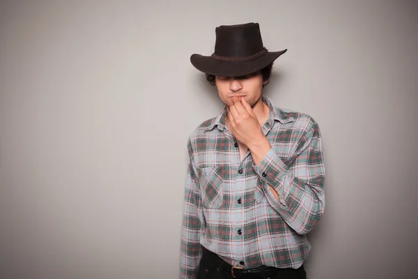 Ung cowboy mot en grön bakgrund — Stockfoto