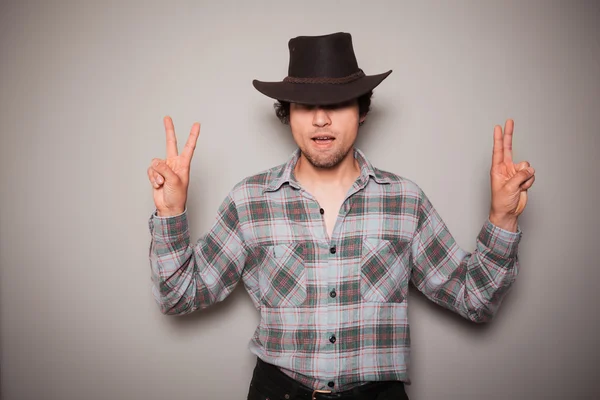 Jonge cowboy tegen een groene achtergrond — Stockfoto