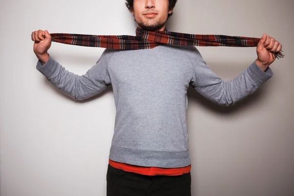 Young man with a scarf against split colored background — Stock Photo, Image
