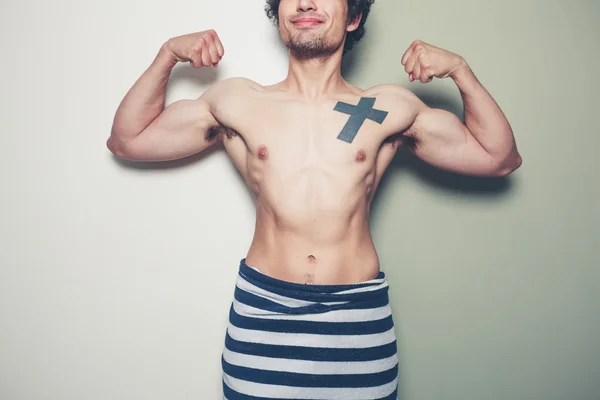 Athletic young man with a towel around his waist — Stock Photo, Image