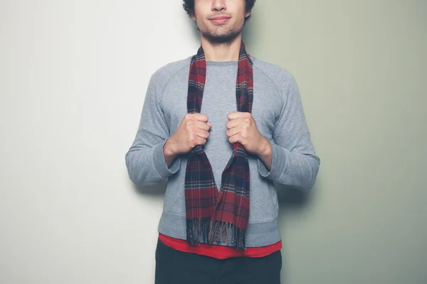 Jonge man met een sjaal tegen splitsen gekleurde achtergrond — Stockfoto
