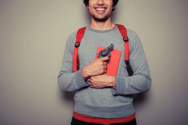 Studente con pistola e libro — Foto Stock