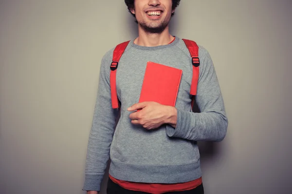 Glückliche junge Studentin mit rotem Buch — Stockfoto