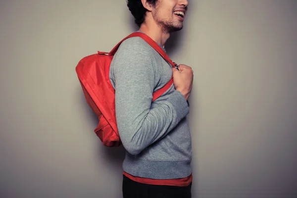 Šťastný mladý student s červeným batohem — Stock fotografie