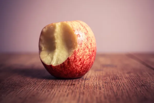 Pomme à moitié mangée sur table en bois — Photo