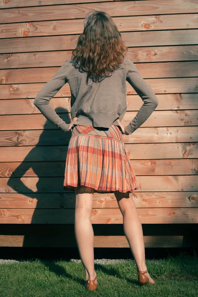 Giovane donna in piedi fuori cabina di legno — Foto Stock