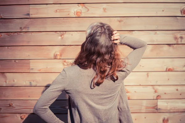Förvirrad ung kvinna utanför trä stuga — Stockfoto
