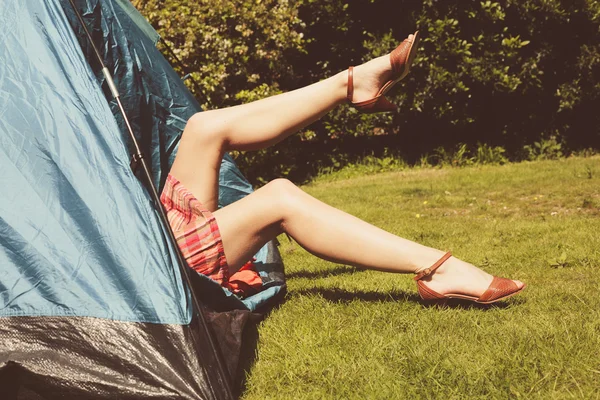 Jonge vrouw verhogen haar benen uit in een tent — Stockfoto