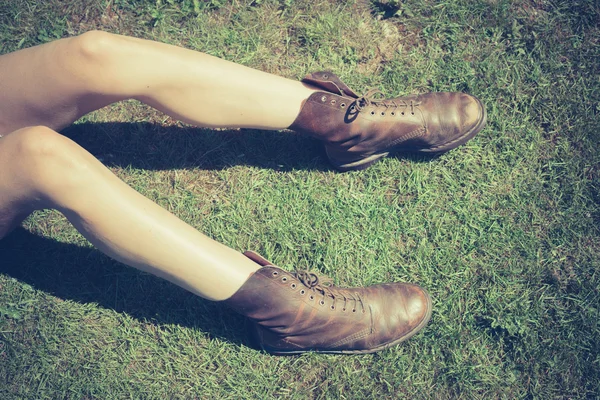 Mladá žena si nohy v trávě — Stock fotografie