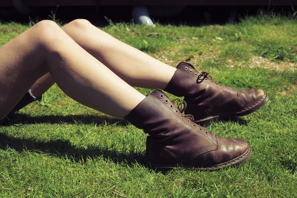 Les jambes et les pieds de la jeune femme sur l'herbe — Photo