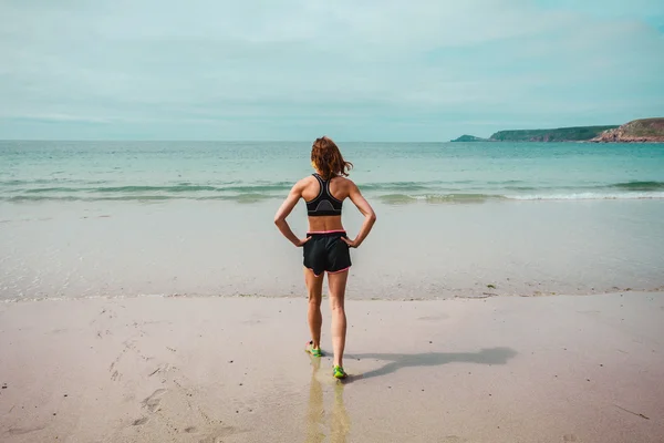 Adatto giovane donna in piedi sulla spiaggia — Foto Stock