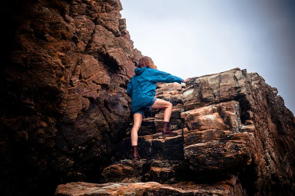 Jonge vrouw klimmend op een rots — Stockfoto
