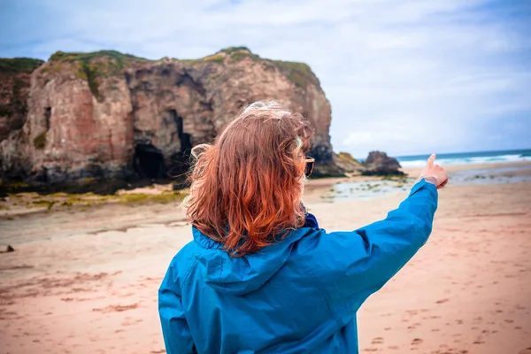 Mujer joven en la playa está señalando —  Fotos de Stock