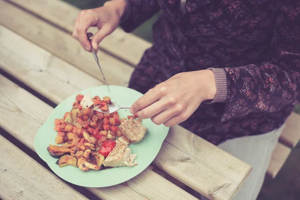 Ung kvinna äta på grill — Stockfoto