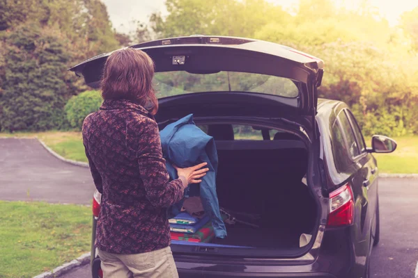 Mujer joven abriendo el maletero del coche — Foto de Stock