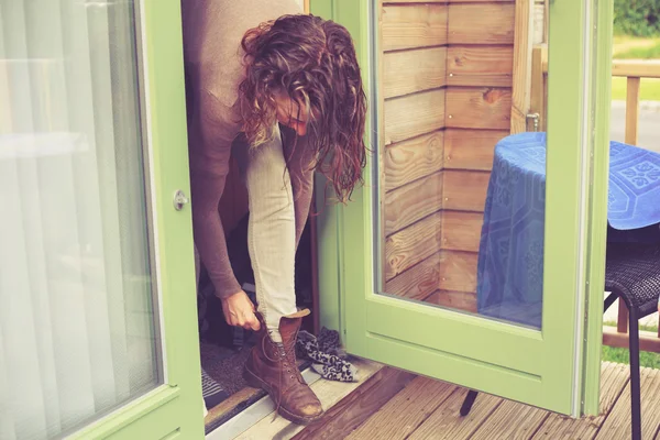 女人在度假小屋里绑她的靴子 — 图库照片