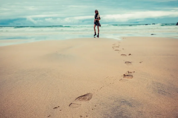 Voetafdrukken achtergelaten door jonge vrouw op strand — Stockfoto