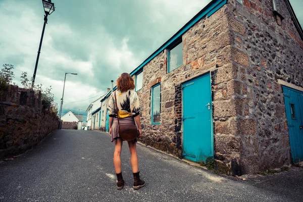 Young woman standing in street outside old house — Stock Photo, Image