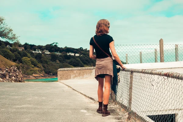 Giovane donna in piedi sulla costa — Foto Stock