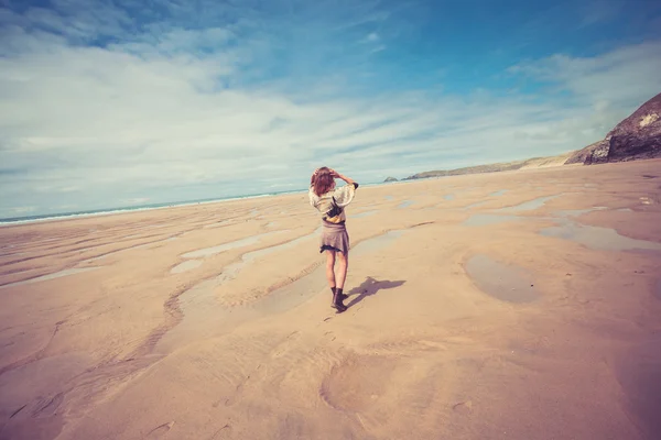 Ung kvinna promenader på stranden — Stockfoto