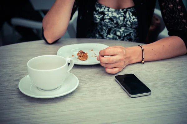 コーヒーを待って電話を持つ女性 — ストック写真