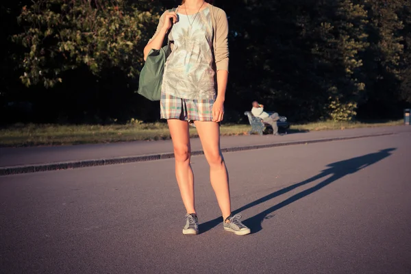Mujer de pie en el parque al atardecer — Foto de Stock