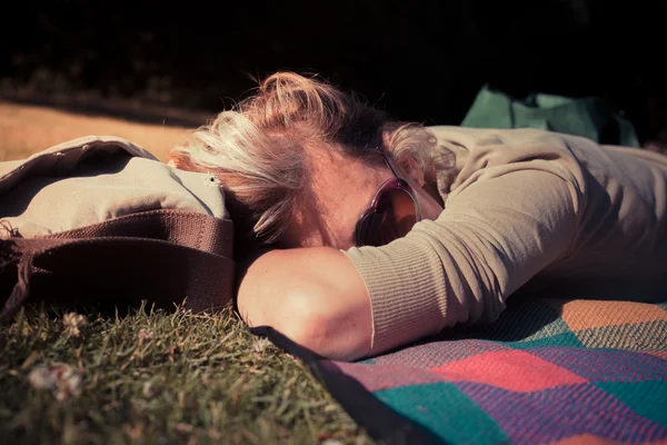 Žena uvolňující na dece při západu slunce — Stock fotografie