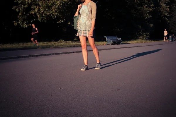 Mujer de pie en el parque al atardecer — Foto de Stock